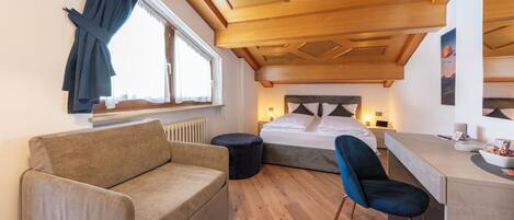 Una habitación moderna con techo de madera, una cama, un sofá, un escritorio y una silla.