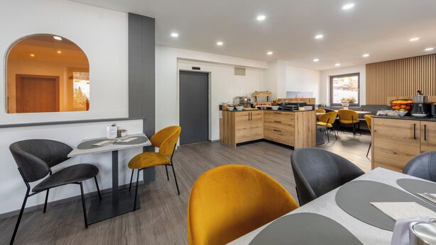 A modern hotel room with a dining area, a kitchen, and a large window. - Kyrr Smart Mountain Retreat (Moena)