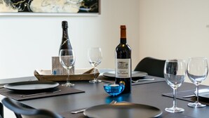 A dining table set with plates, glasses, and a bottle of wine. - Artemis Gvo2 Apartment in Koksijde Near the Beach (Koksijde)