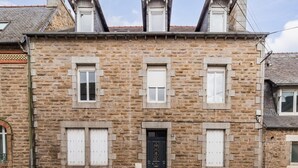 A stone building with a symmetrical facade, featuring three windows on the ground floor and a central door with a decorative design. - Central and charming studio, Guingamp center (Guingamp)