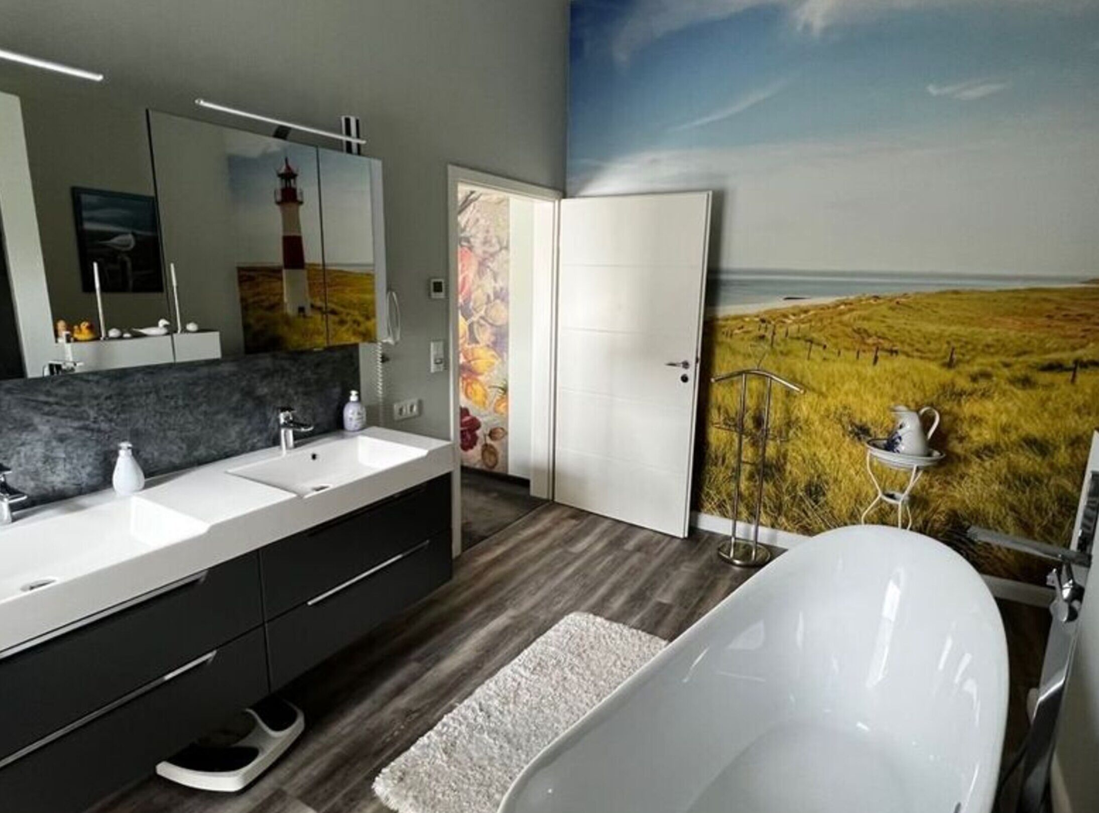 Une salle de bain moderne avec une grande baignoire, deux lavabos et un miroir.