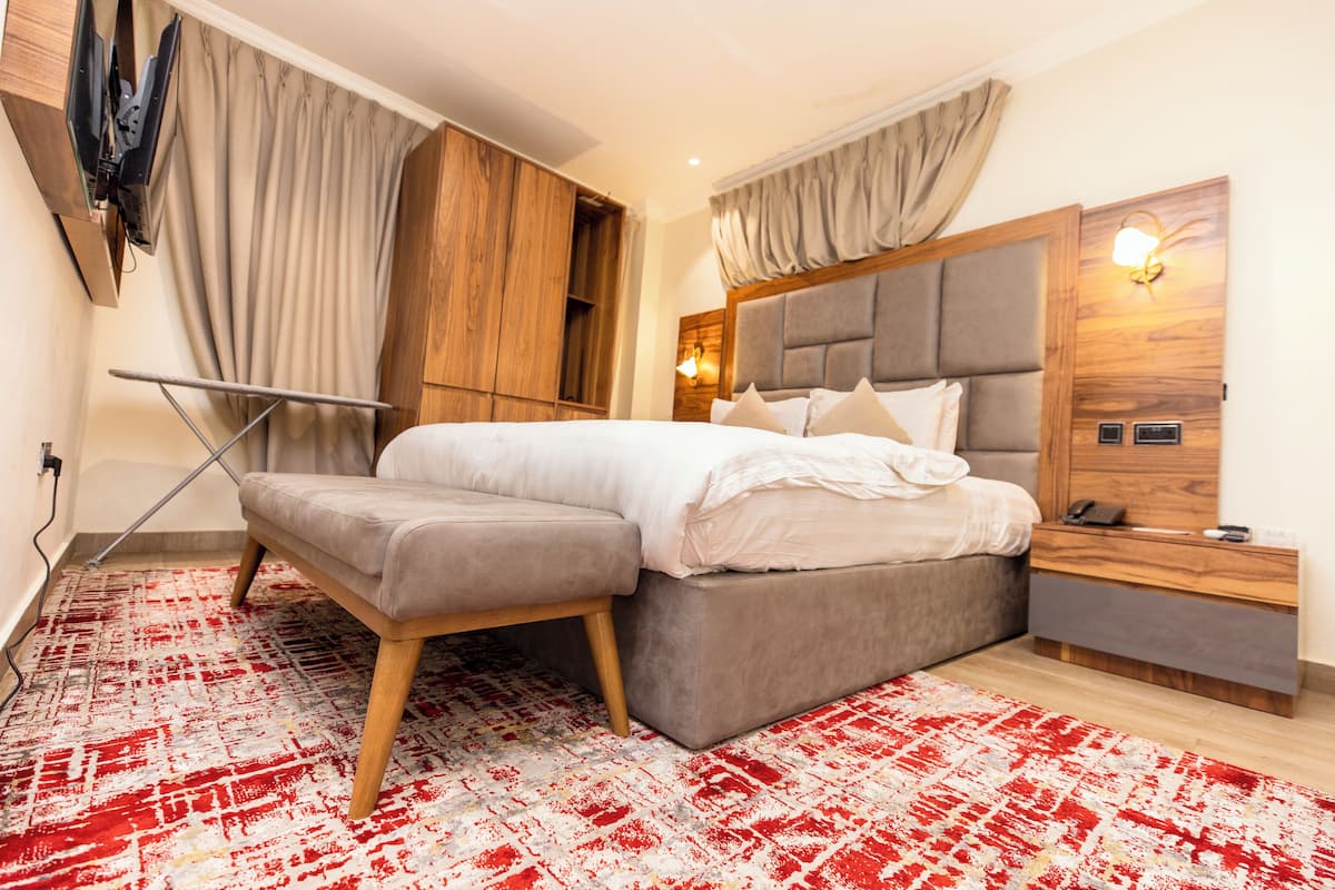 A modern bedroom with a bed, bedside table, and a built-in TV.