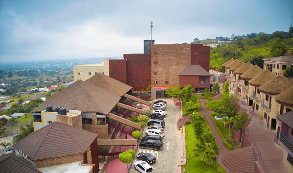 A hotel with multiple buildings, a parking area, and a view of the surrounding landscape. - Volta Serene Hotel (Ho)