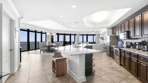 A spacious kitchen with a large island, modern appliances, and a view of the ocean. - Beachfront!  Lazy River, Restaurant, New condo! (Orange Beach)
