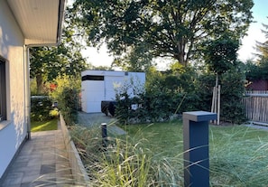 Ein modernes Haus mit gepflasterter Auffahrt, einem kleinen Garten und einer weißen Garage.