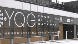 The exterior of Windsor International Airport with a large sign reading "YQG YOUR QUICK GATEWAY".
