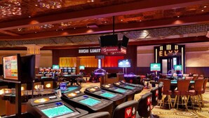 A casino with multiple gaming tables and chairs, a high-limit blackjack area, and a sign for ELVY.