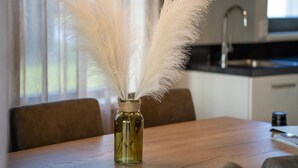 A dining table with a vase of white feathers. - Holiday Home in Scherpenisse Near Nature Reserve (Scherpenisse)