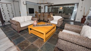 A spacious living area with a large wooden coffee table, patterned sofas, and a stone-tiled floor. - Luxury Villa With a Swimming Pool in Hoedspruit (Hoedspruit)