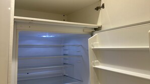 Ein leerer, weißer Kühlschrank mit mehreren Einlegeböden und einem Gefrierfach.
