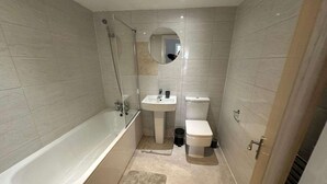 Un baño moderno con bañera, lavabo e inodoro.