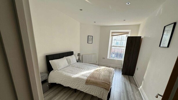 Un dormitorio con cama, ventana y radiador.