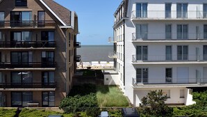 A modern apartment building with multiple floors, balconies, and a view of the sea. - Stylish Stay in De Haan (De Haan)