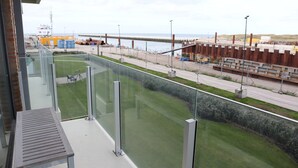 A balcony with a view of a construction site and a grassy area. - Apartment in Nieuwpoort With sea View (Nieuwpoort)