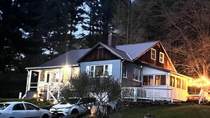 A two-story house with a stone foundation, a porch, and a garage.