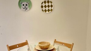 Ein runder Glastisch mit einer gewebten Tischmatte und einer Holzschüssel, umgeben von Holzkästen mit Metallbeinen.
