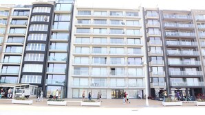 A multi-story residential building with balconies, large windows, and a central entrance. - Apartment in Nieuwpoort by the Beach (Nieuwpoort)
