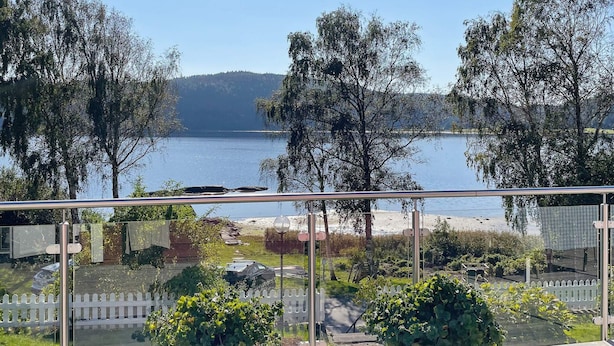 Een balkon met uitzicht op een meer en bomen.