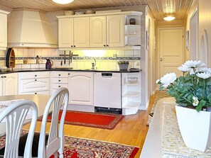 A kitchen with white cabinets, a dishwasher, and a red rug. - 4 Star Holiday Home in Uddevalla (Uddevalla)