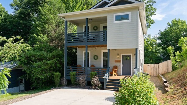 A two-story house with a balcony, a porch, and a wooden fence. - Asheville`s 5 Star Club!  We Invite You To See What All The Fuss Is About! (Asheville)