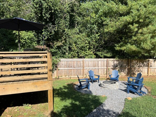 A backyard with a wooden deck, a fire pit, and blue Adirondack chairs. - Asheville`s 5 Star Club! Our fall colors shine bright! (Asheville)
