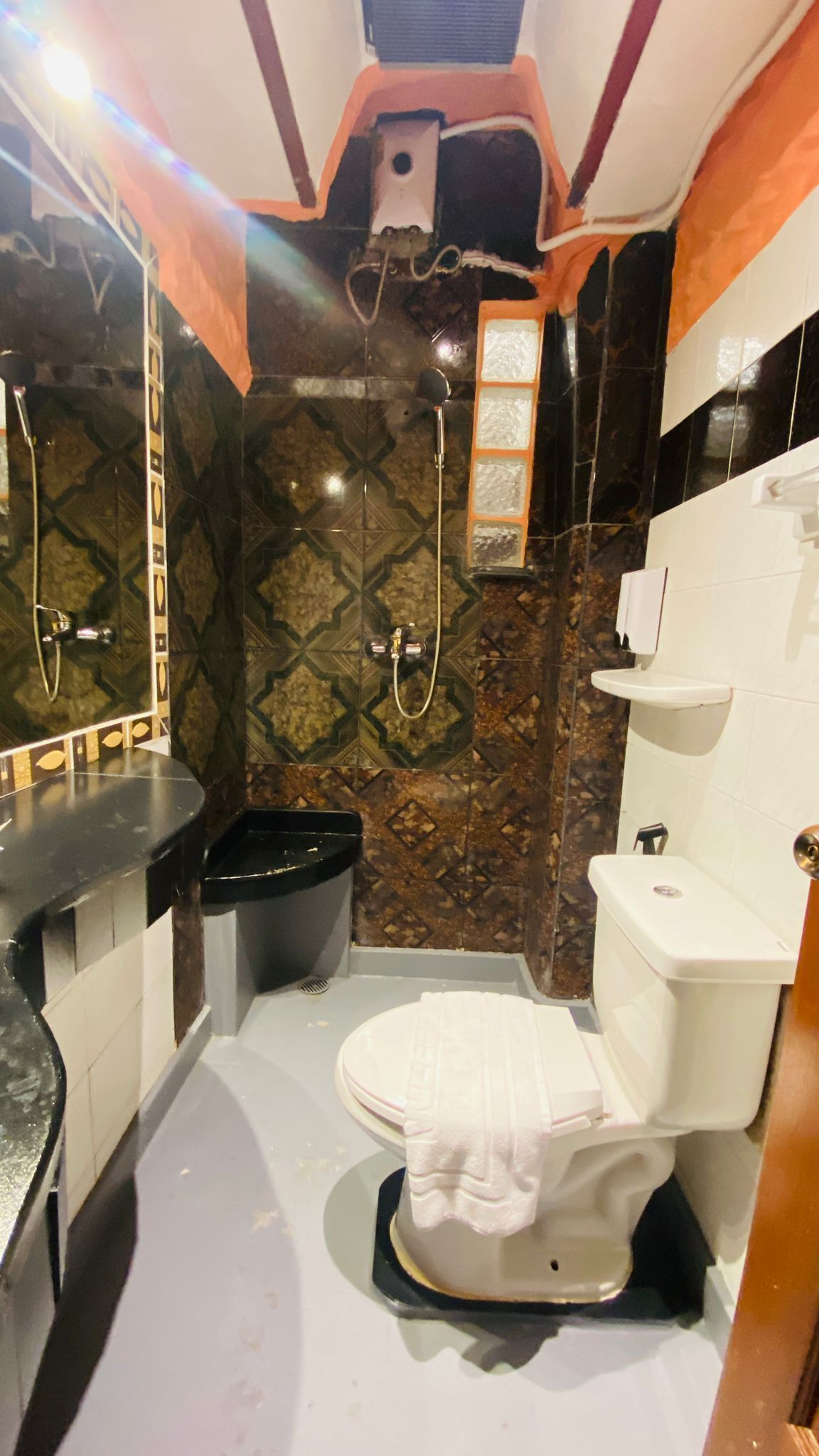 A compact bathroom with a shower, toilet, and sink.