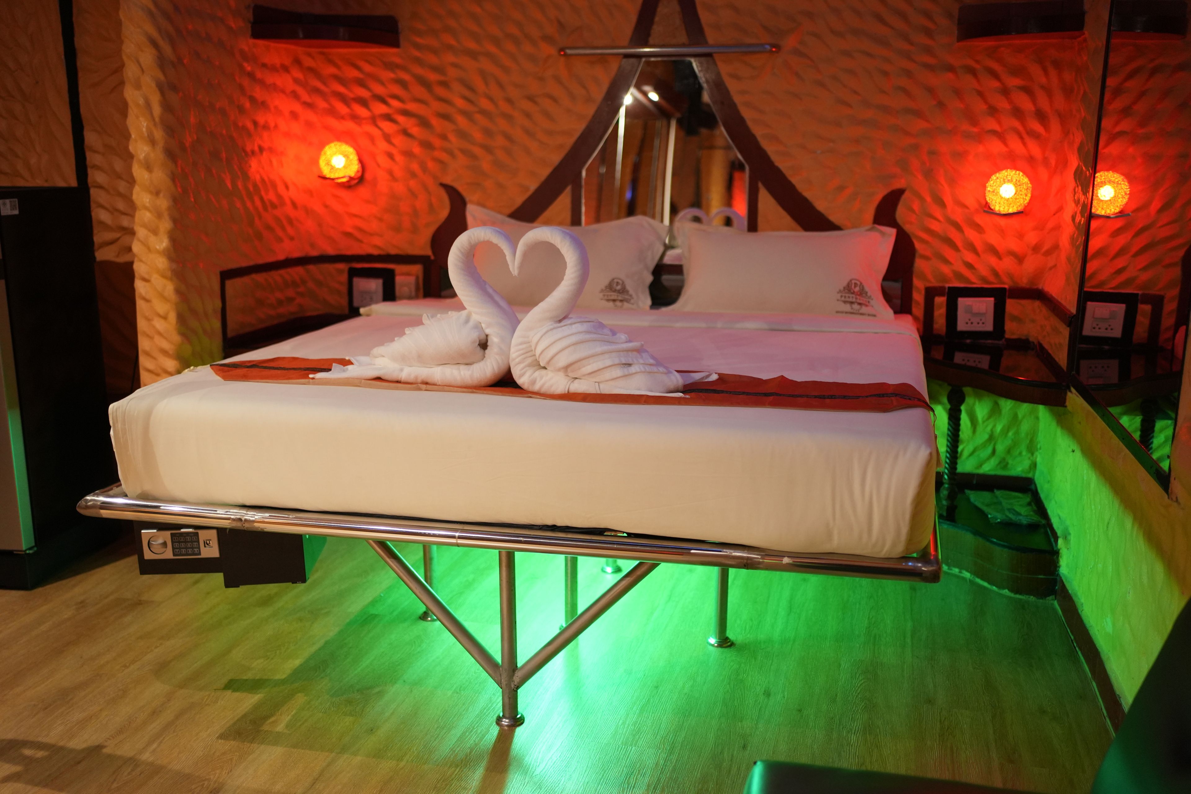 A bed with a unique design, including two swan-shaped pillows and a heart-shaped pillow.