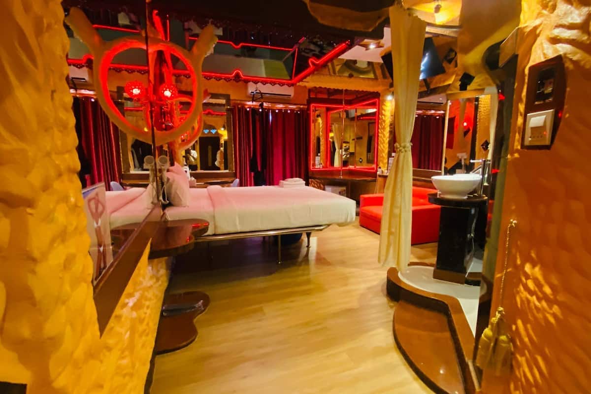 A room with a bed, a mirror, and a red circular decoration.