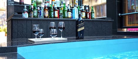 A bar area with a variety of liquor bottles and glasses on a counter.