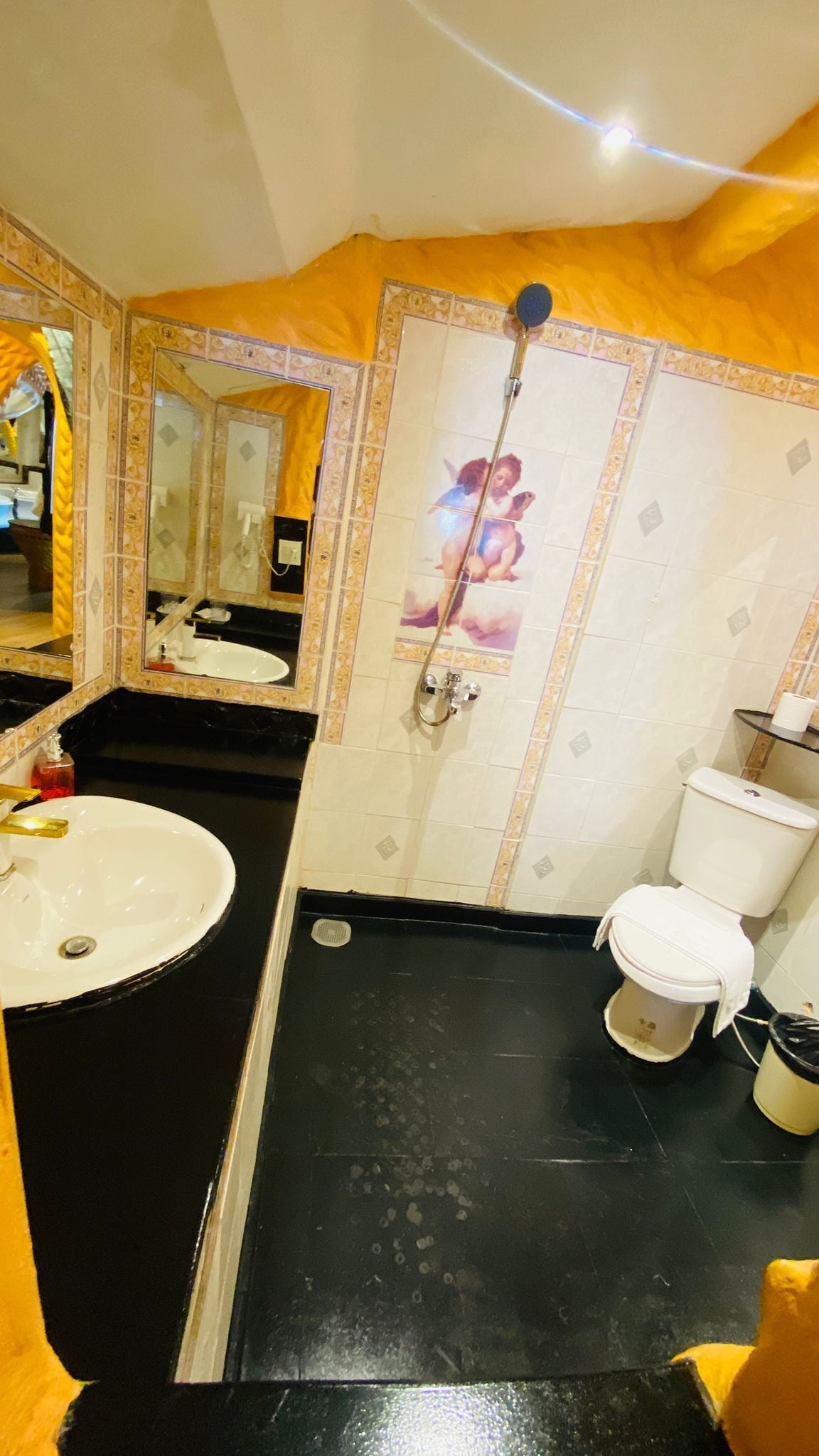 Un baño con lavamanos, inodoro y ducha.