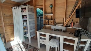 A wooden interior with a white table, shelves with decorative items, and a television mounted on the wall. - Charm and tranquility, panoramic views of the sea and the islands, 3 minutes from the beaches (porticcio)