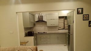 A compact kitchen with a gas stove, a built-in oven, and a stainless steel refrigerator. - Impeccable 3-bed Apartment in Lahore (Lahore)