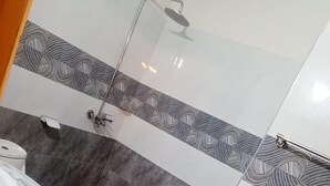 A bathroom with a curved vanity, a shower, and patterned tiles. - Impeccable 3-bed Apartment in Lahore (Lahore)