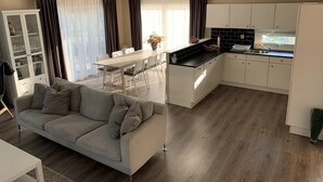 A modern kitchen with white cabinets, a black countertop, and a window. - Holiday Home on the Recreational Lake (Lathum)