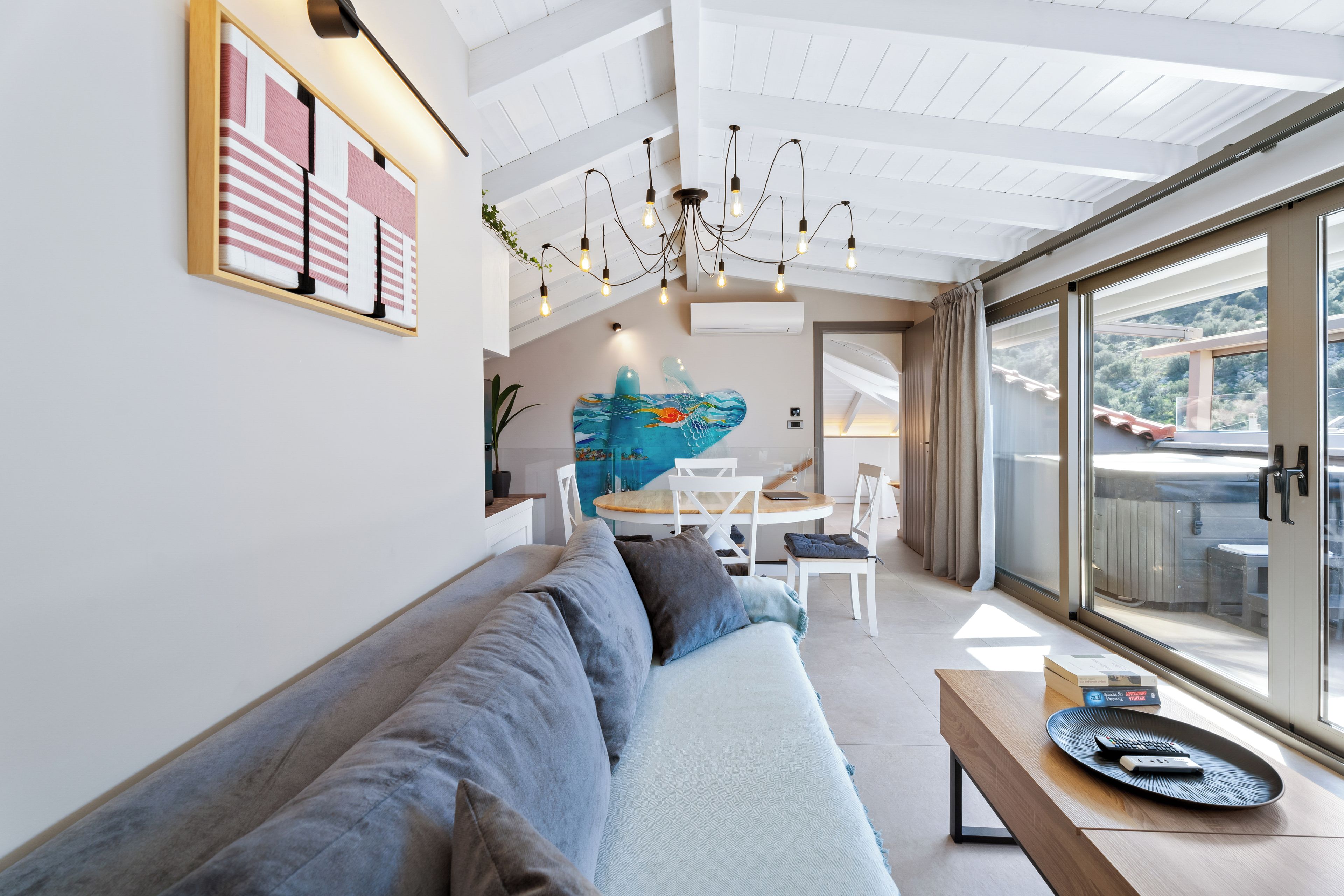 Uma sala de estar moderna com sofá, área de refeições e uma janela grande.