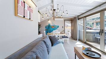 Uma sala de estar moderna com sofá, área de refeições e uma janela grande.