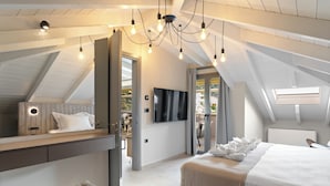 Un dormitorio moderno con un entrepiso para dormir, una cama grande y un televisor.