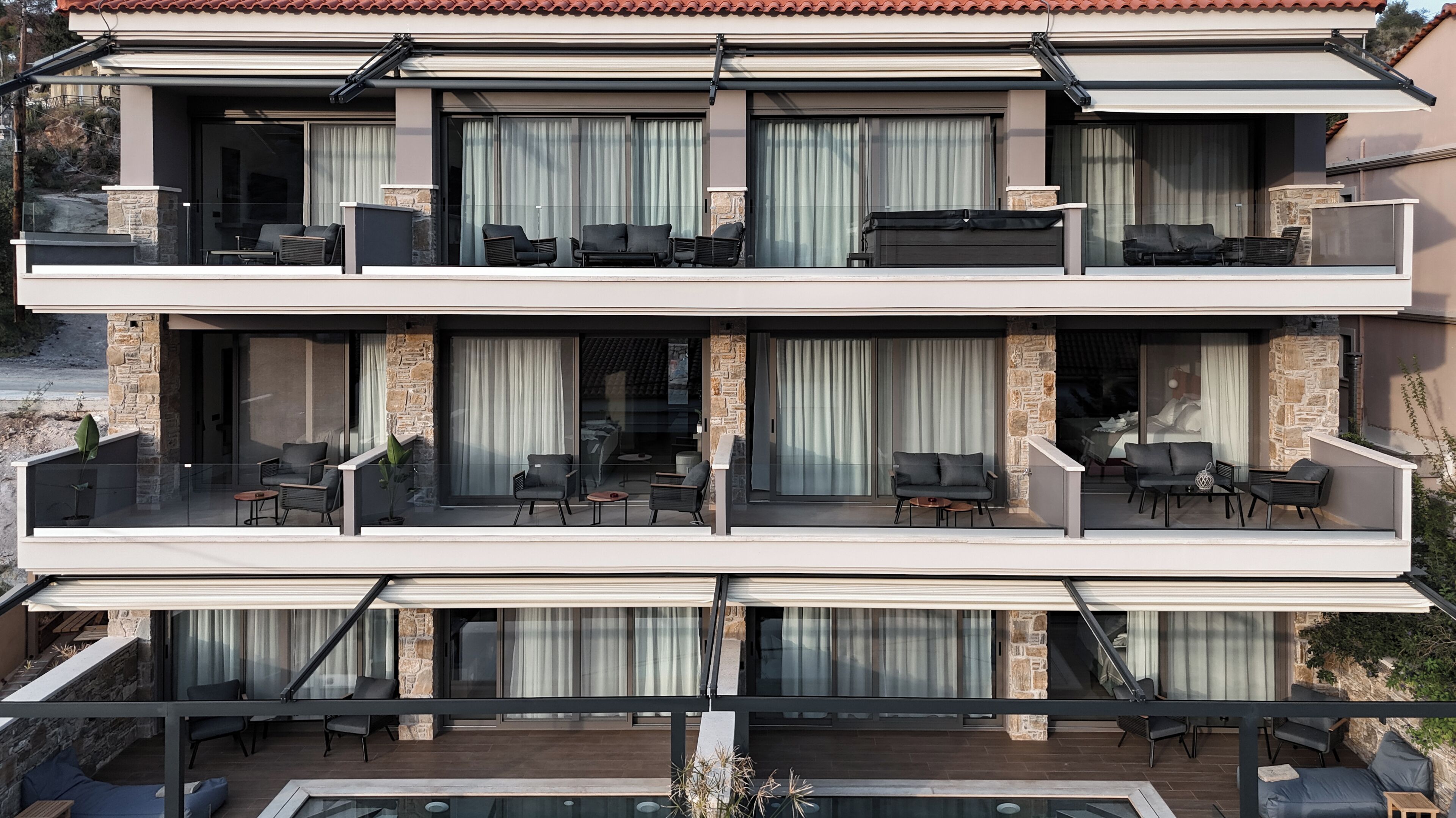 A multi-story residential building with balconies, outdoor seating, and a swimming pool.