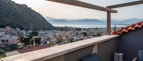 A balcony with a view of a cityscape and mountains.
