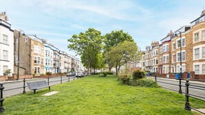A row of terraced houses with a grassy area in the middle.
