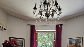 A room with a washing machine, a dining table with chairs, a chandelier, and patterned floor tiles. - 1 Bedroom Apartment in Mondello (Mondello)