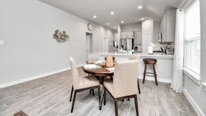 A modern kitchen with white cabinets, a stainless steel refrigerator, and a built-in oven. - Exquisite 4 Bedroom Brand New Home in Katy (Katy)