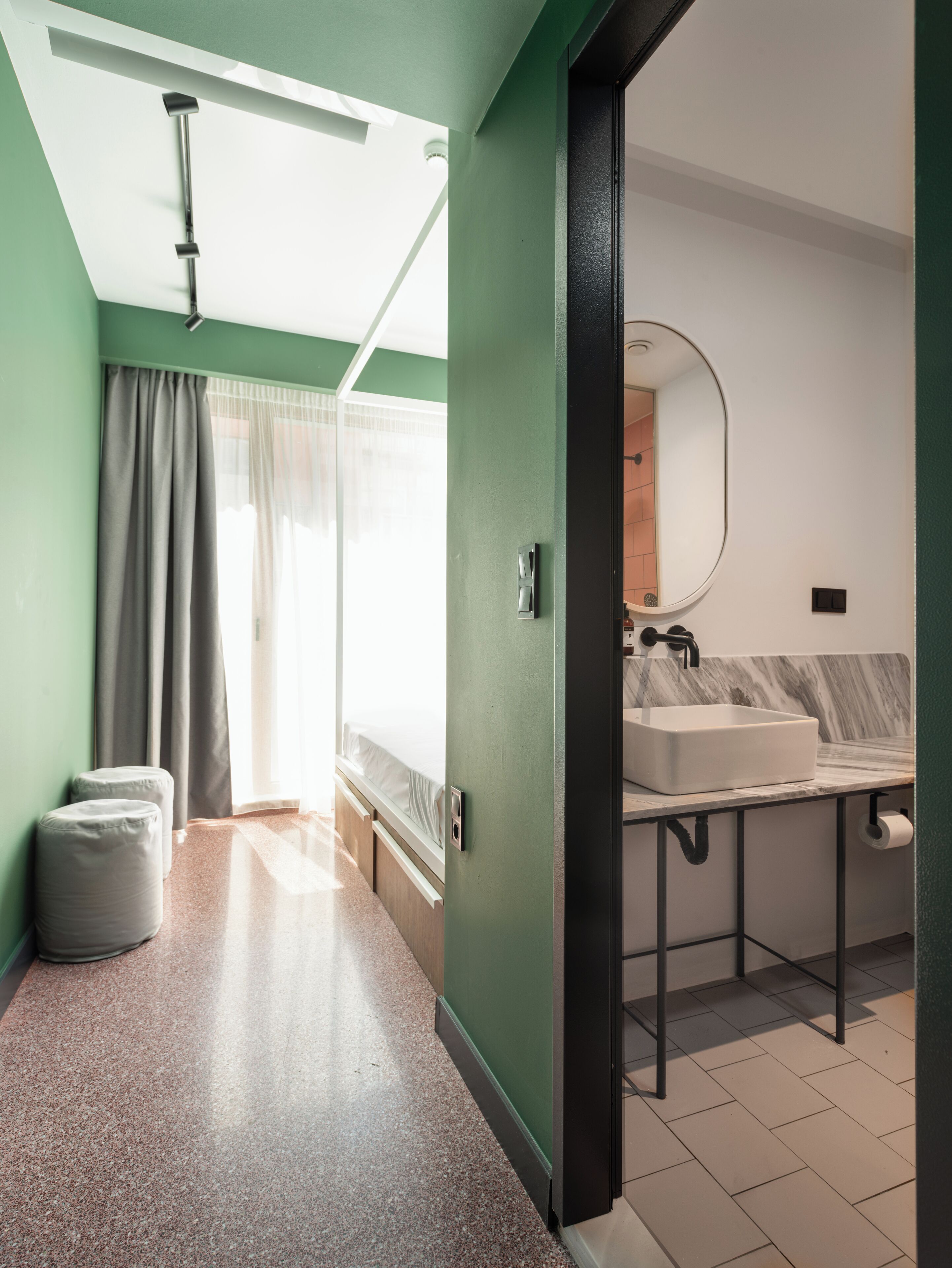 A modern bathroom with a large mirror, a sink, and a toilet.