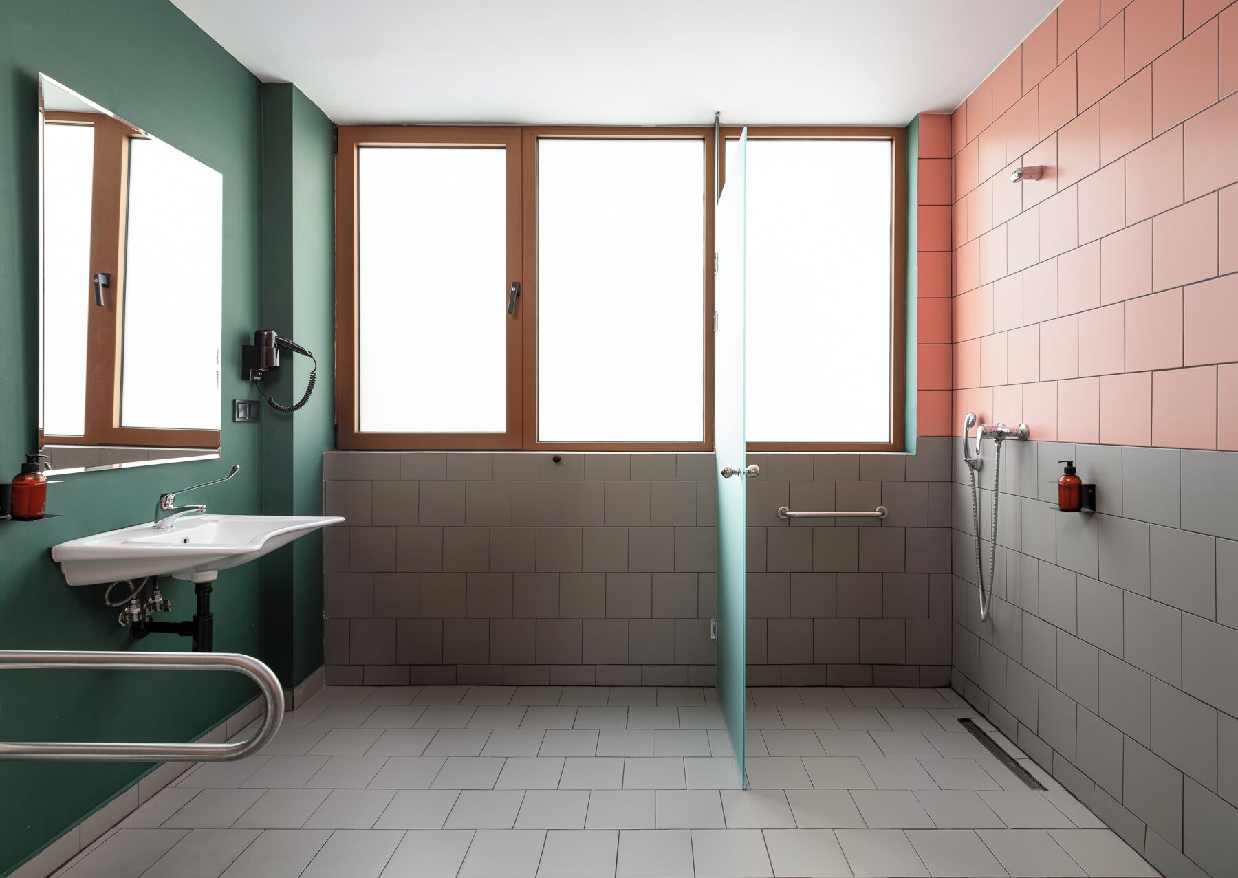 A modern bathroom with a shower, a sink, and a mirror.