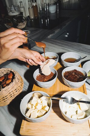 A tray with various food items including bowls of soup, a basket of bread, and a bowl of tofu. - Zeus is Loose Hostel (Thessaloniki)