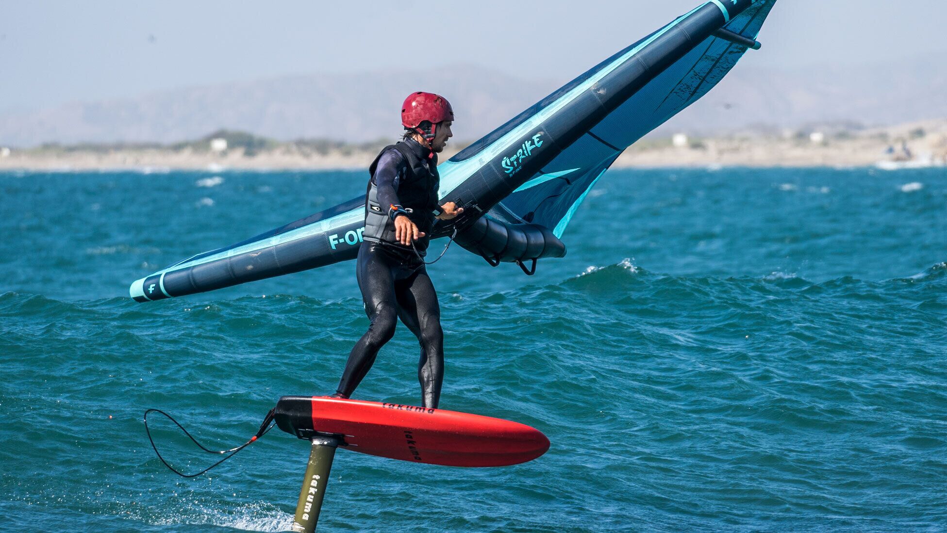 A person windsurfing with a board and sail.