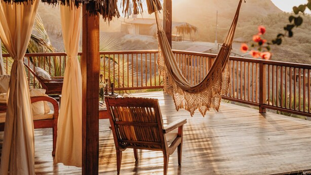 A wooden deck with a thatched roof, a hammock, and a bench. - VILLA DEL SOL  (Máncora)