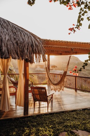 A wooden deck with a thatched roof, a hammock, and a bench. - VILLA DEL SOL  (Máncora)