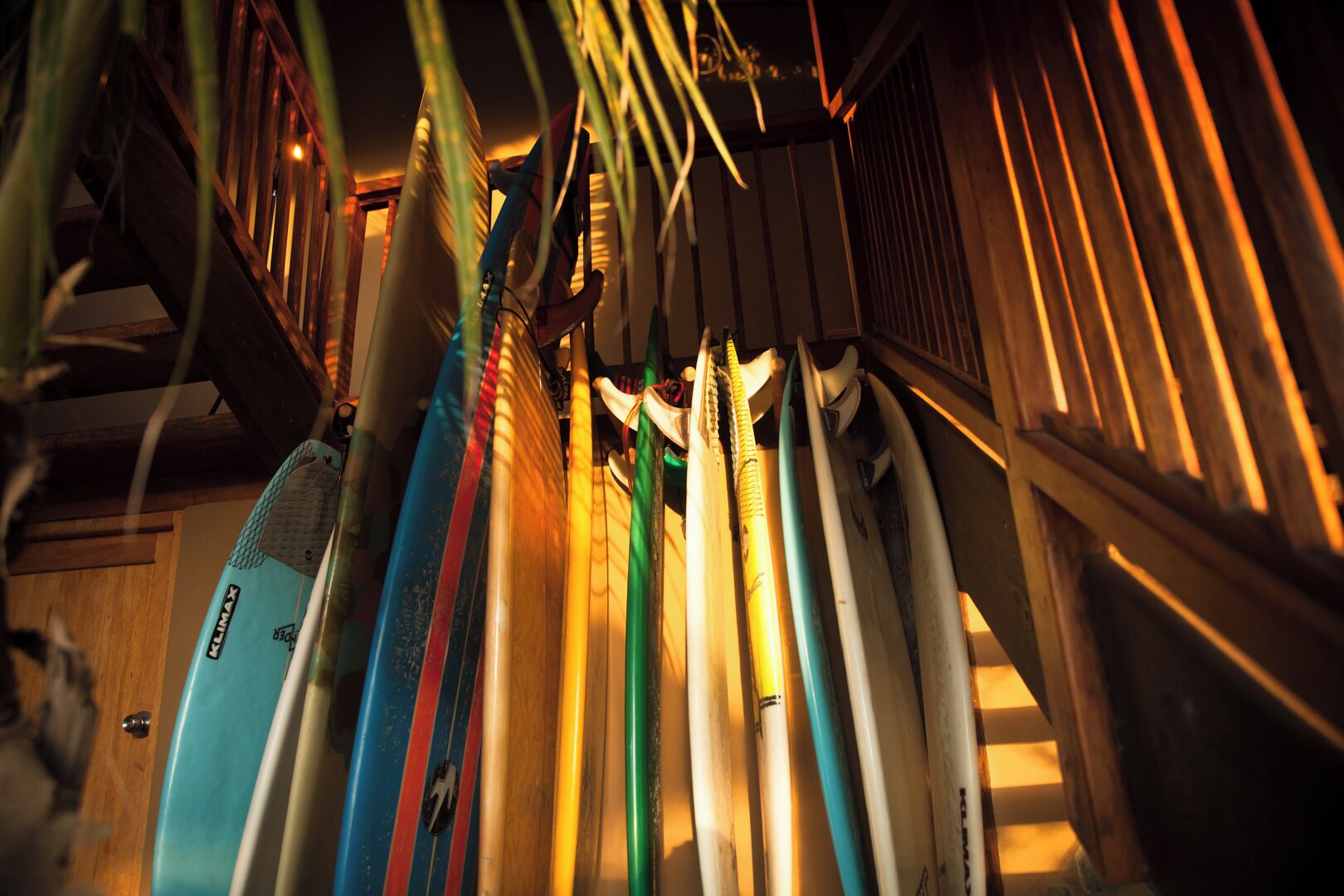 A collection of surfboards leaning against a wooden structure.