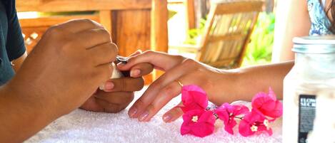 A close-up of hands receiving a manicure.